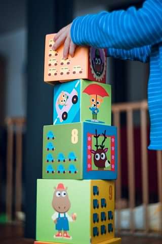 Childrens' play blocks are stacked by small hands