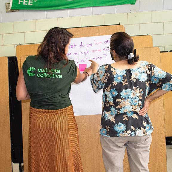 Two teachers write on a whiteboard